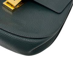 Green leather Drew shoulder bag corner seam and curved bottom in close-up