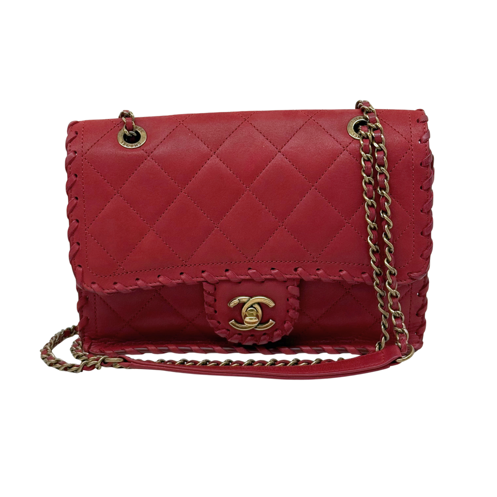 Chanel red quilted flap bag side view with gold-tone CC clasp and chain strap