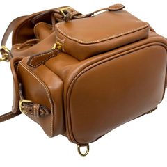 Brown leather backpack top and back view with flap closure, gold-tone hardware, and handle loop.