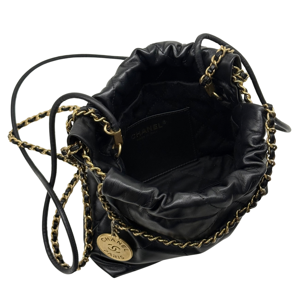 Black quilted mini hobo crossbody bag with gold chain strap and interior logo lining.