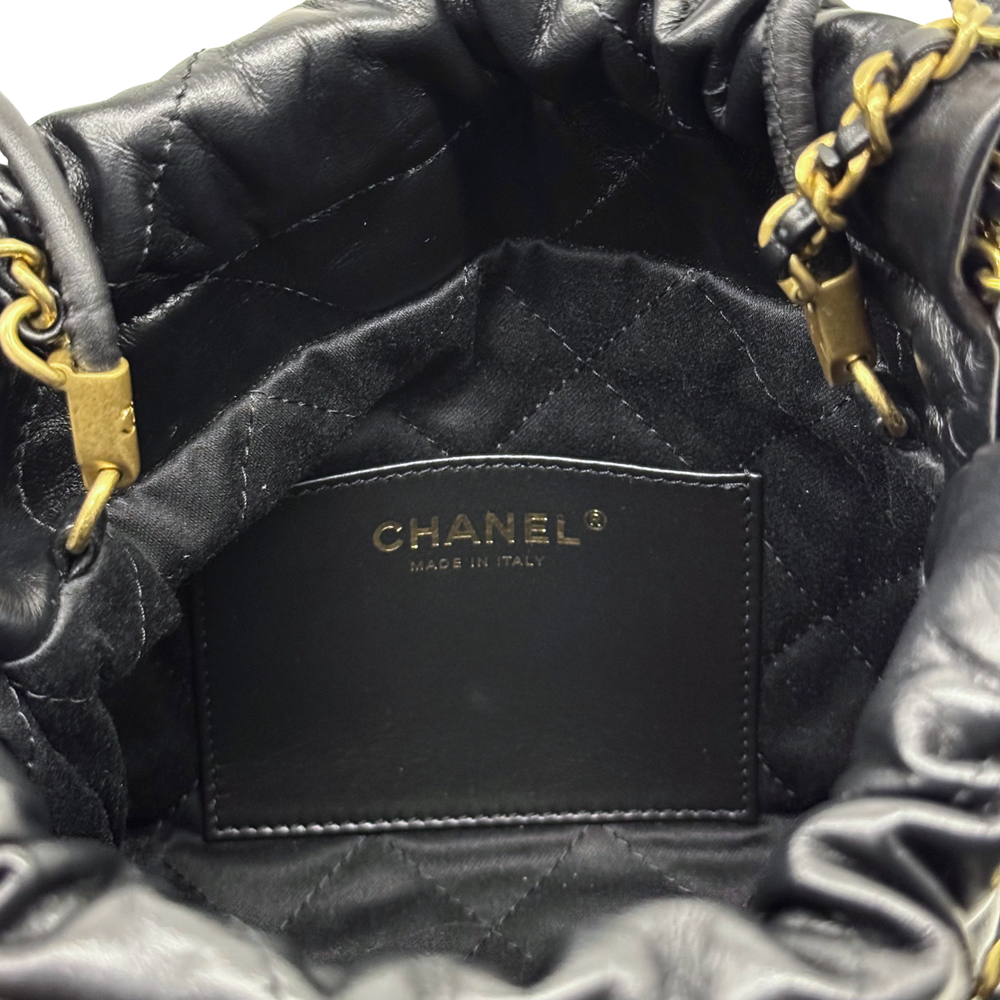Black quilted Chanel mini crossbody bag interior panel with Chanel patch and gold chain strap.