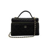 Black Chanel quilted leather handbag with top handle, gold zip, and chain strap