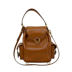 Brown leather mini backpack with front flap, drawstring details, and adjustable shoulder straps.