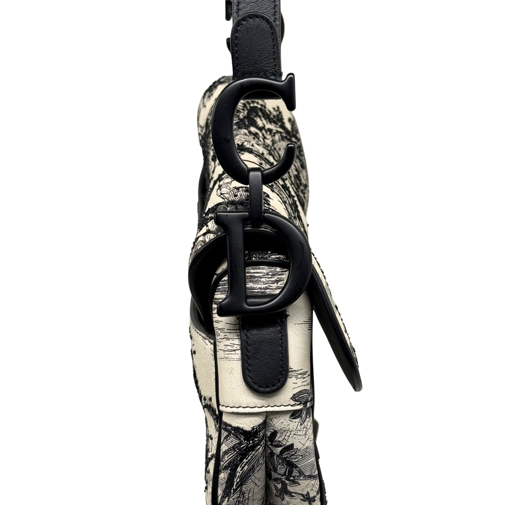 Christian Dior saddle bag side strap with black leather buckle and toile-covered strap base.