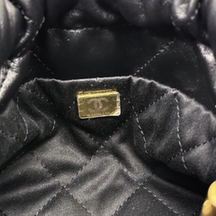 Black quilted calfskin mini crossbody bag with gold-toned Chanel hardware and logo plaque.