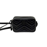 Black leather mini crossbody bag with chevron quilting and GG logo, centered front view.