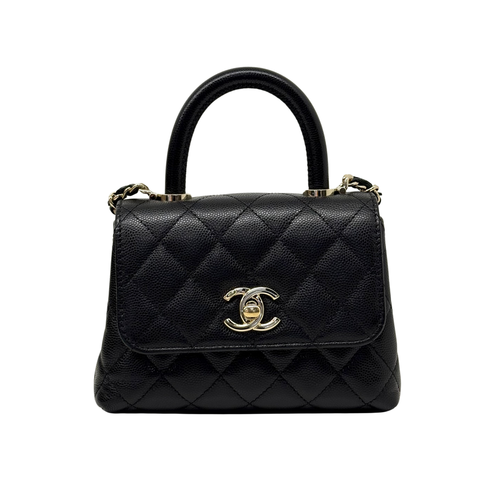 Black quilted leather mini top handle bag with front flap, Chanel logo, and gold hardware