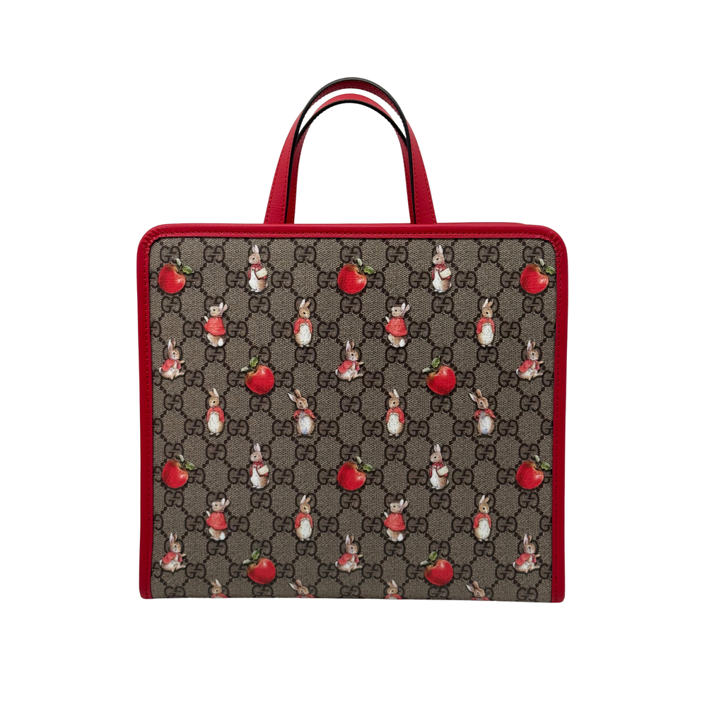 Gucci tote bag front view with red leather handles and GG canvas with rabbit motifs