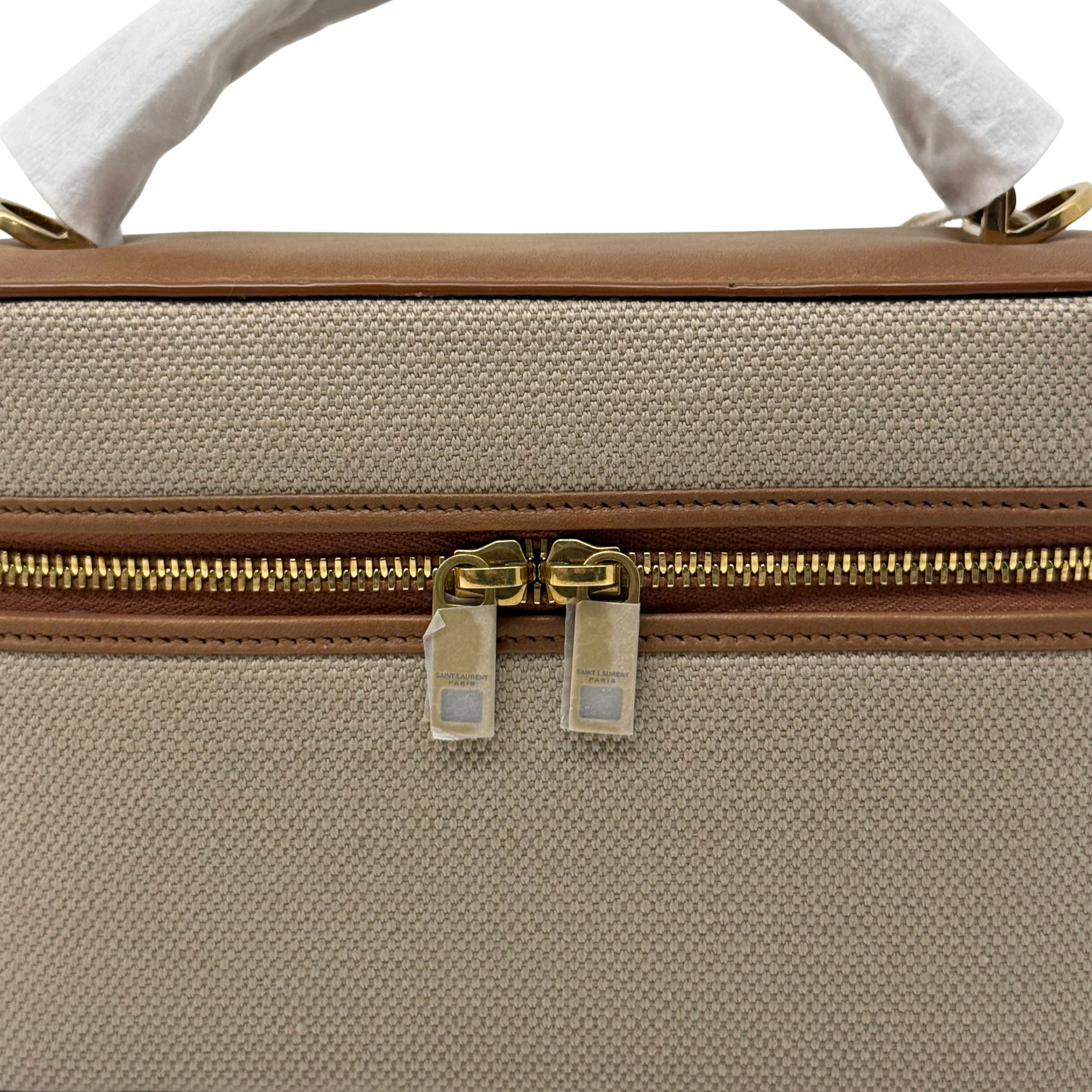 Canvas top with gold double zipper pulls and brown leather trim, handle loop.