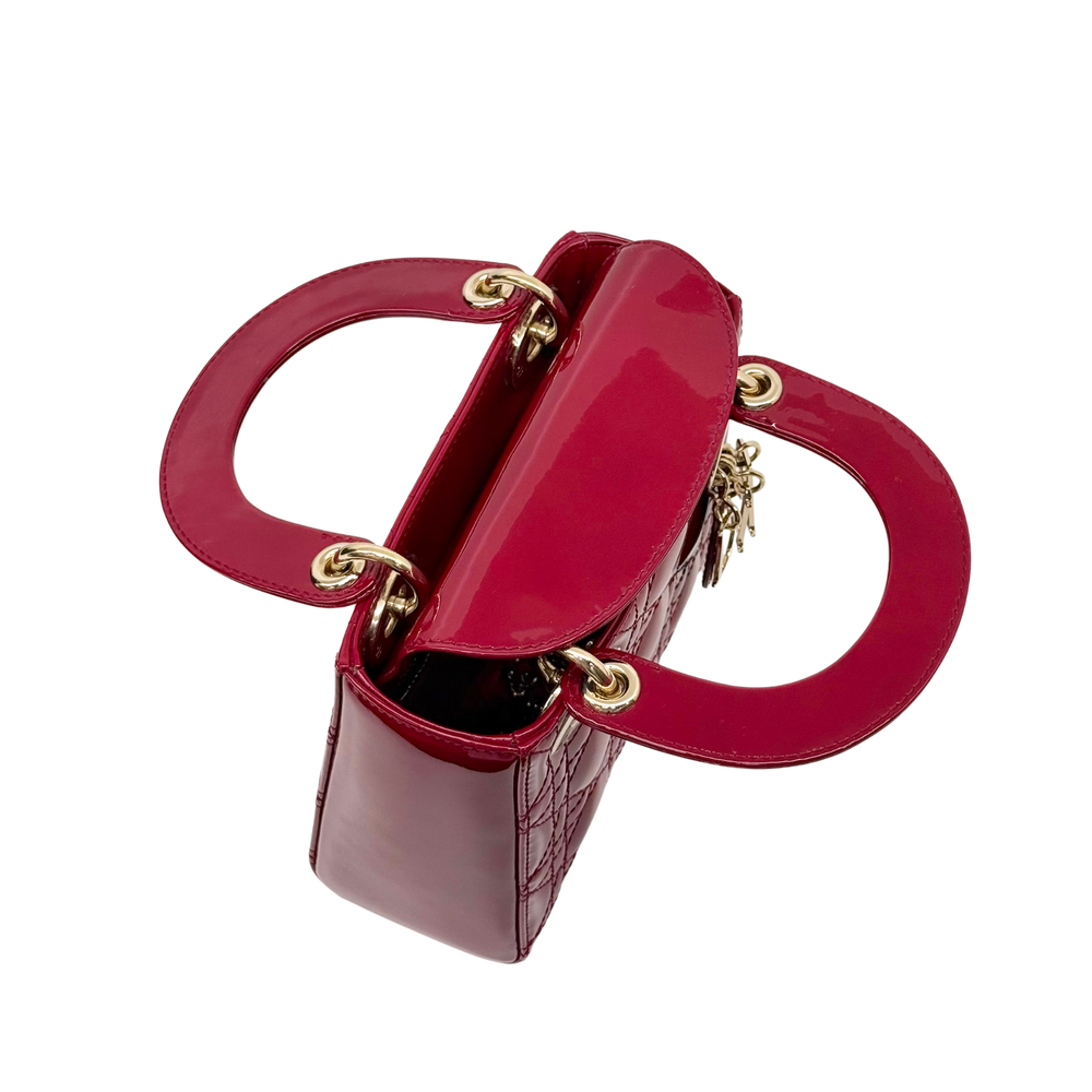 Red patent leather small handbag with gold double handles and strap