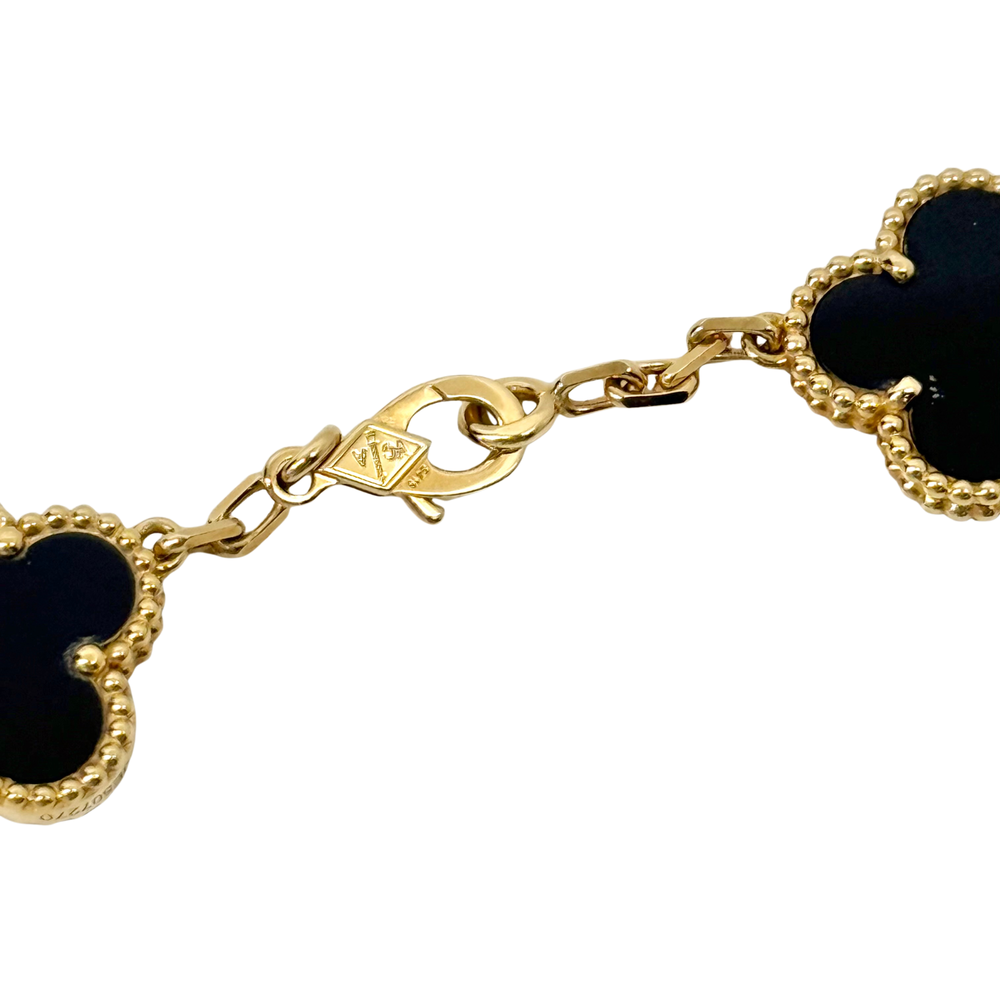 Van Cleef necklace close-up of gold-tone chain and black clover charm edge