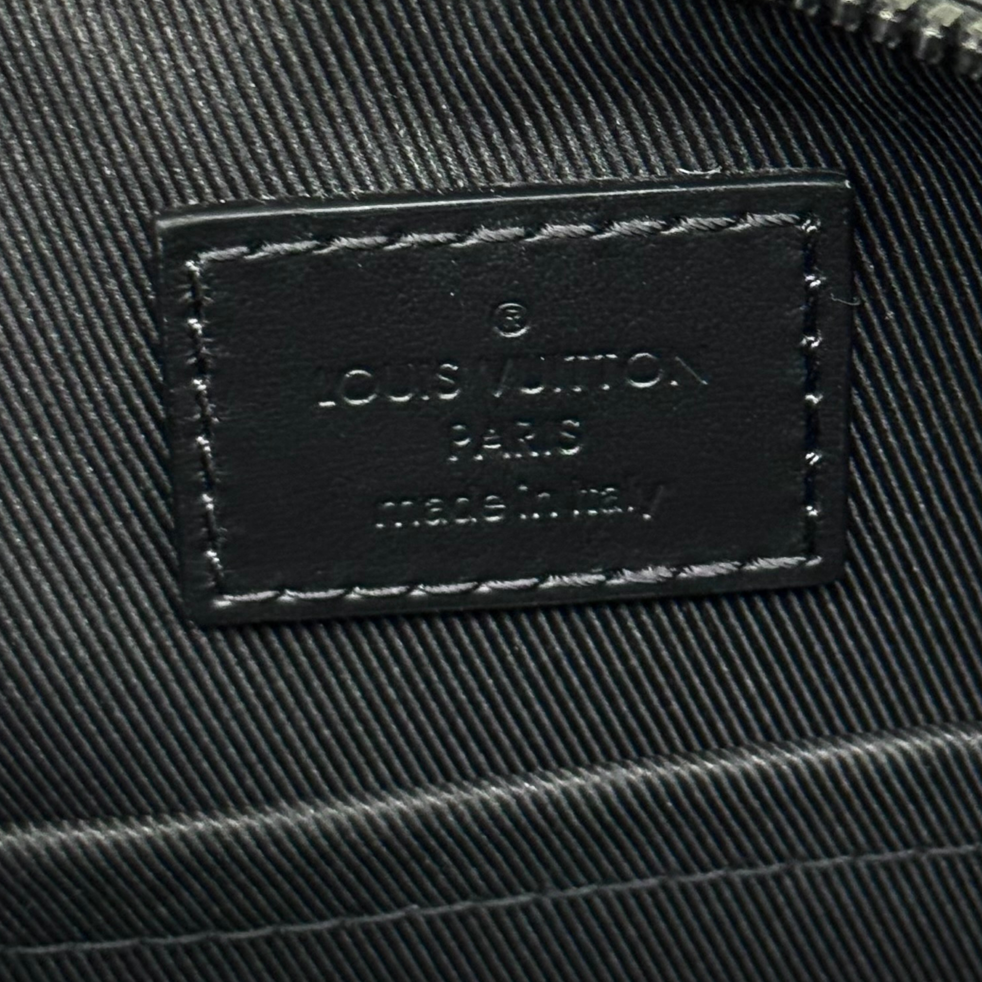 Louis Vuitton Paris leather label on black monogram bag, close-up