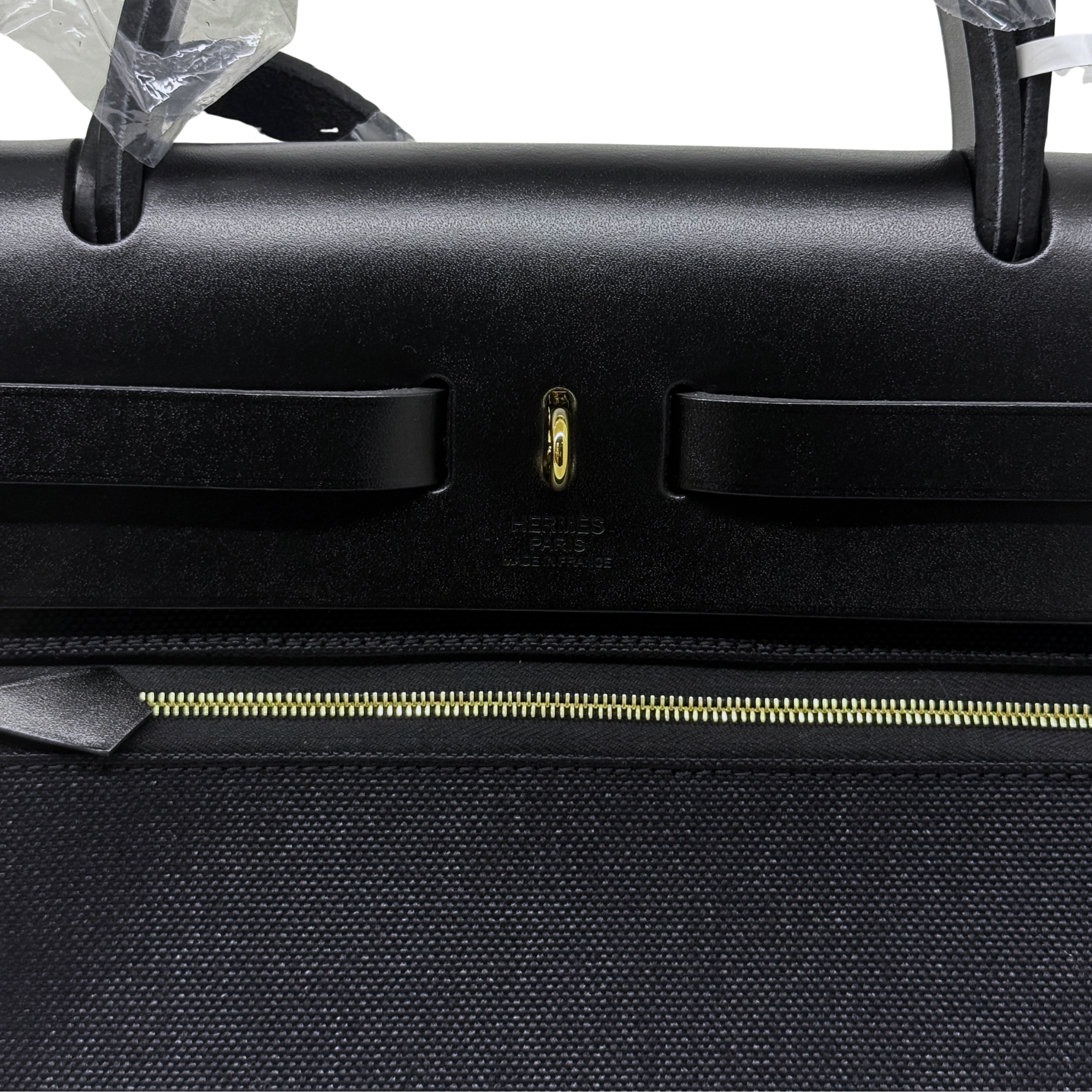 Hermes handbag front close-up with flap hardware and gold zipper line