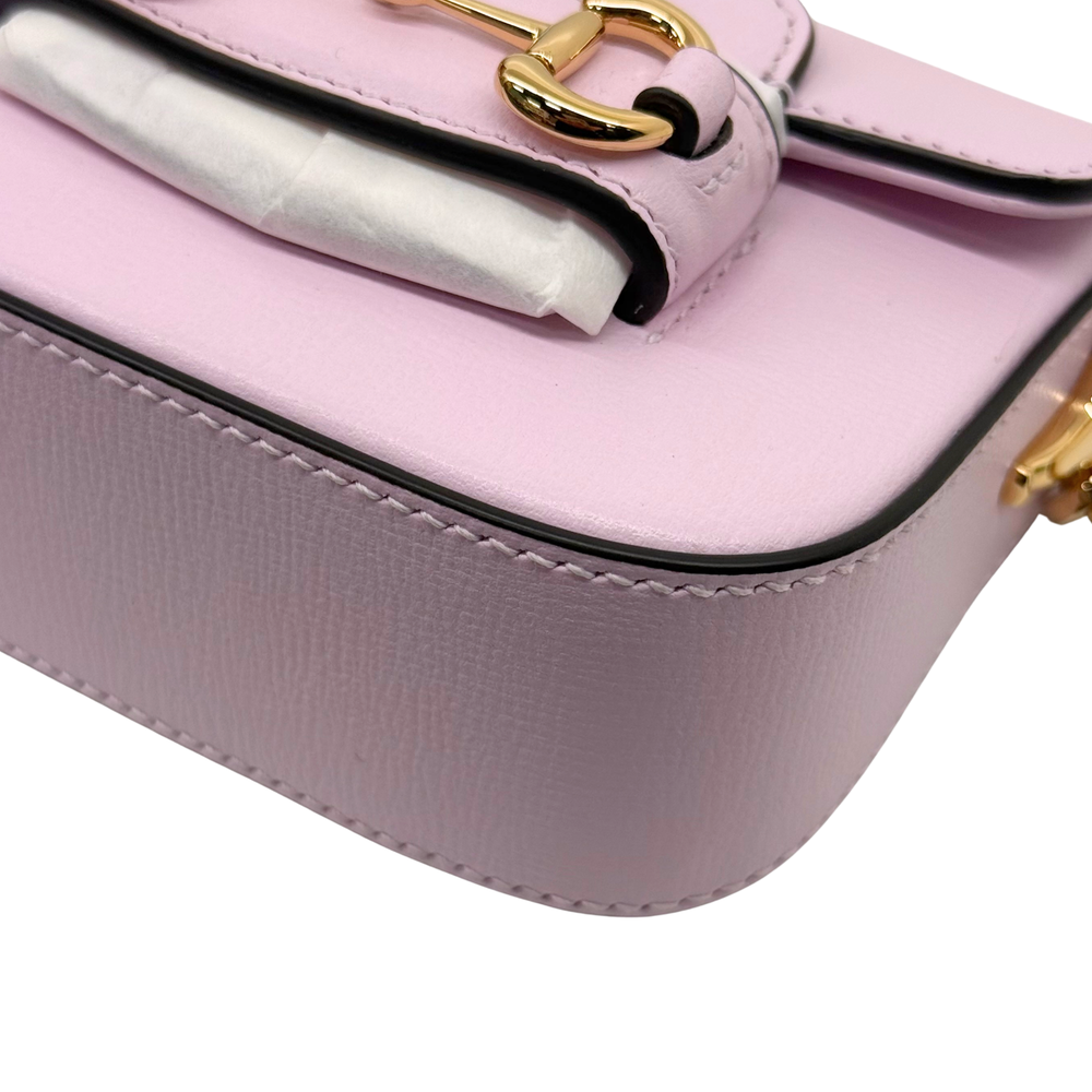 Pink Gucci mini bag corner close-up with gold buckle clasp and black trim