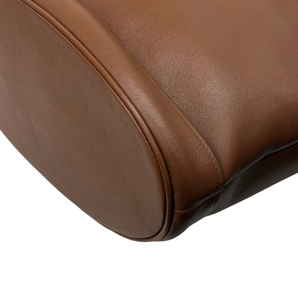 Brown leather bag corner with curved seam and reinforced edge stitching