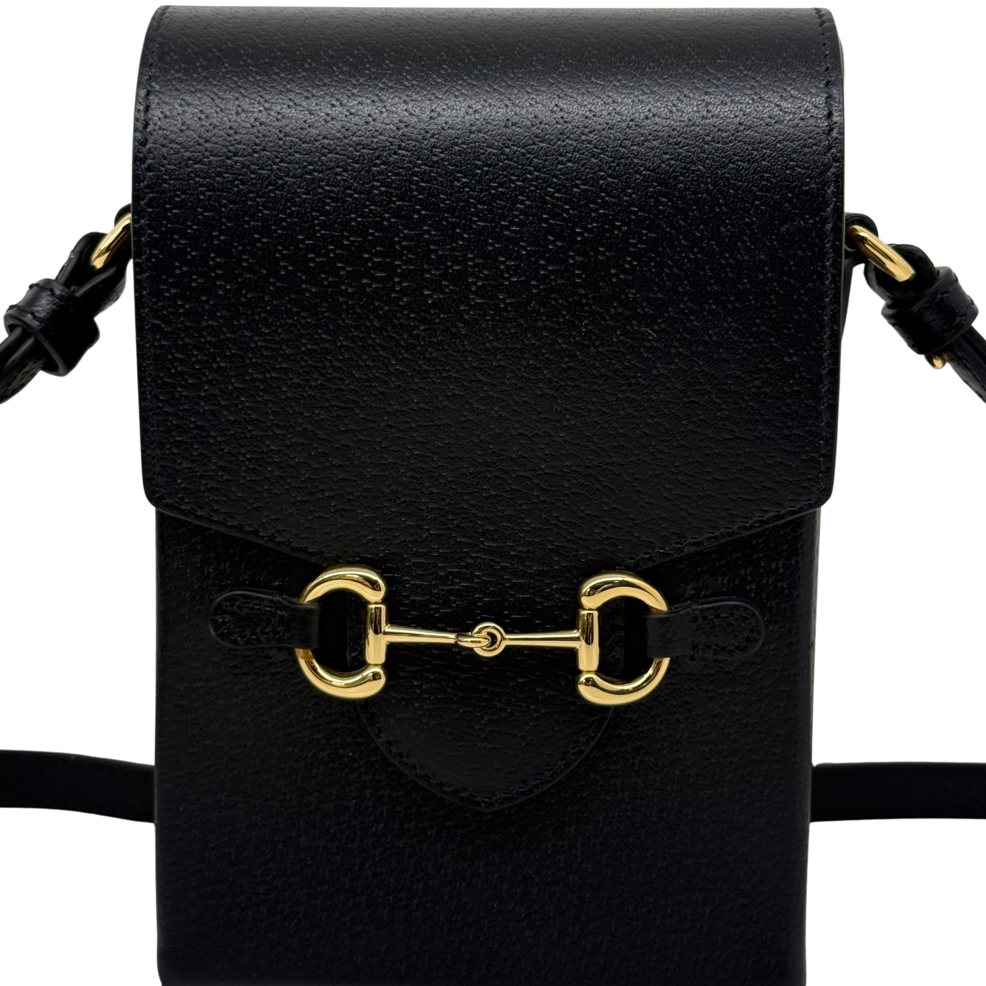Black leather crossbody bag close-up of gold horsebit hardware