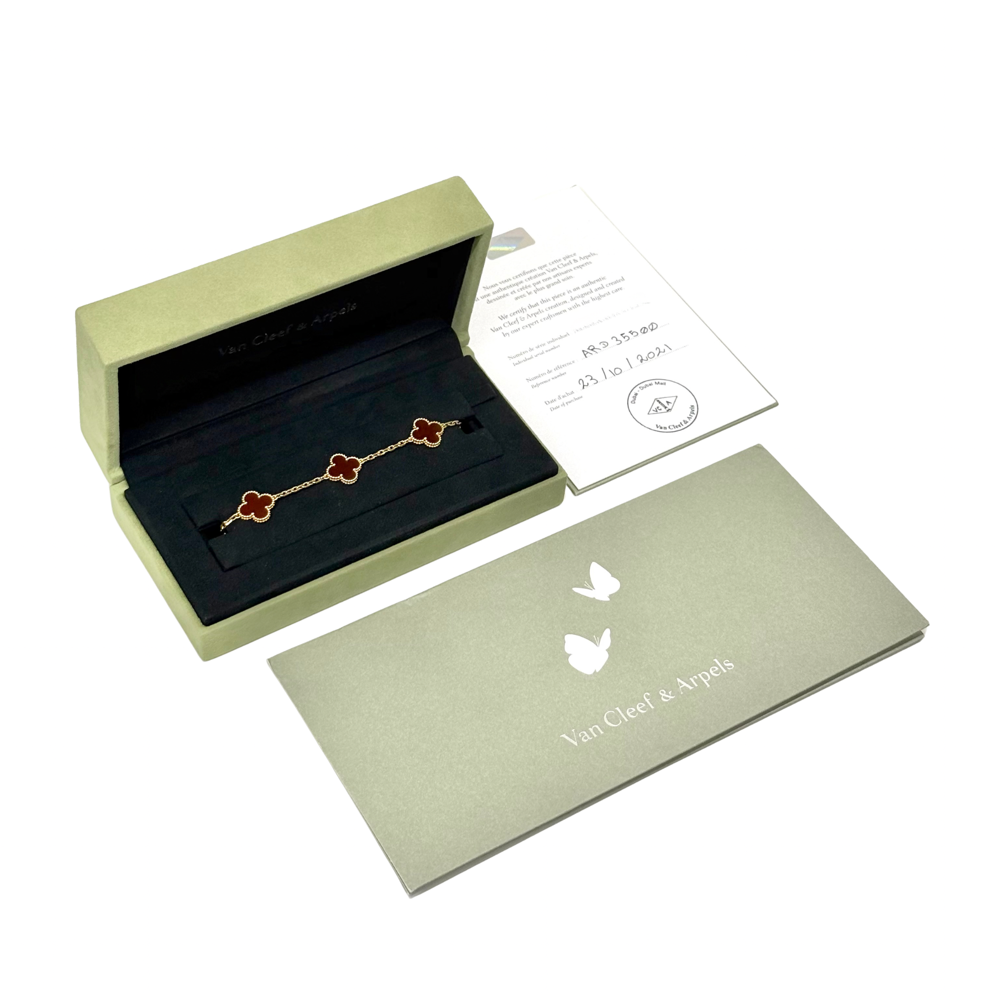 Goldtone bracelet with five red clover motifs, shown in gift box