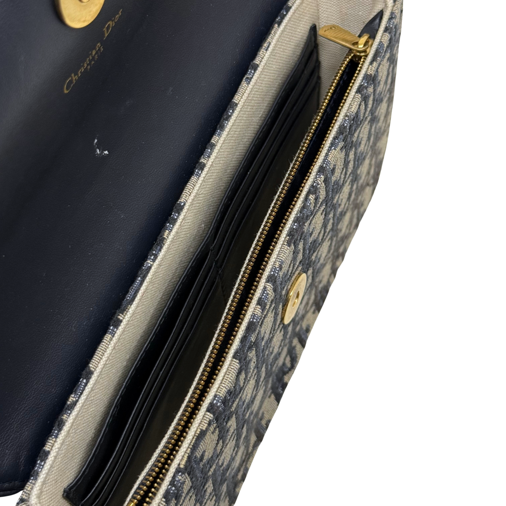 Dior crossbody bag interior view with zipper track and striped fabric lining