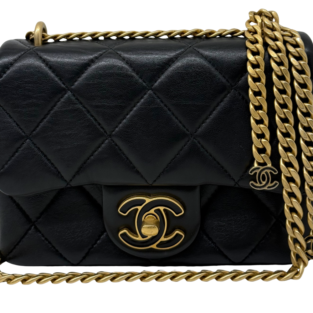 Black quilted flap bag with gold CC-style emblem and chain strap