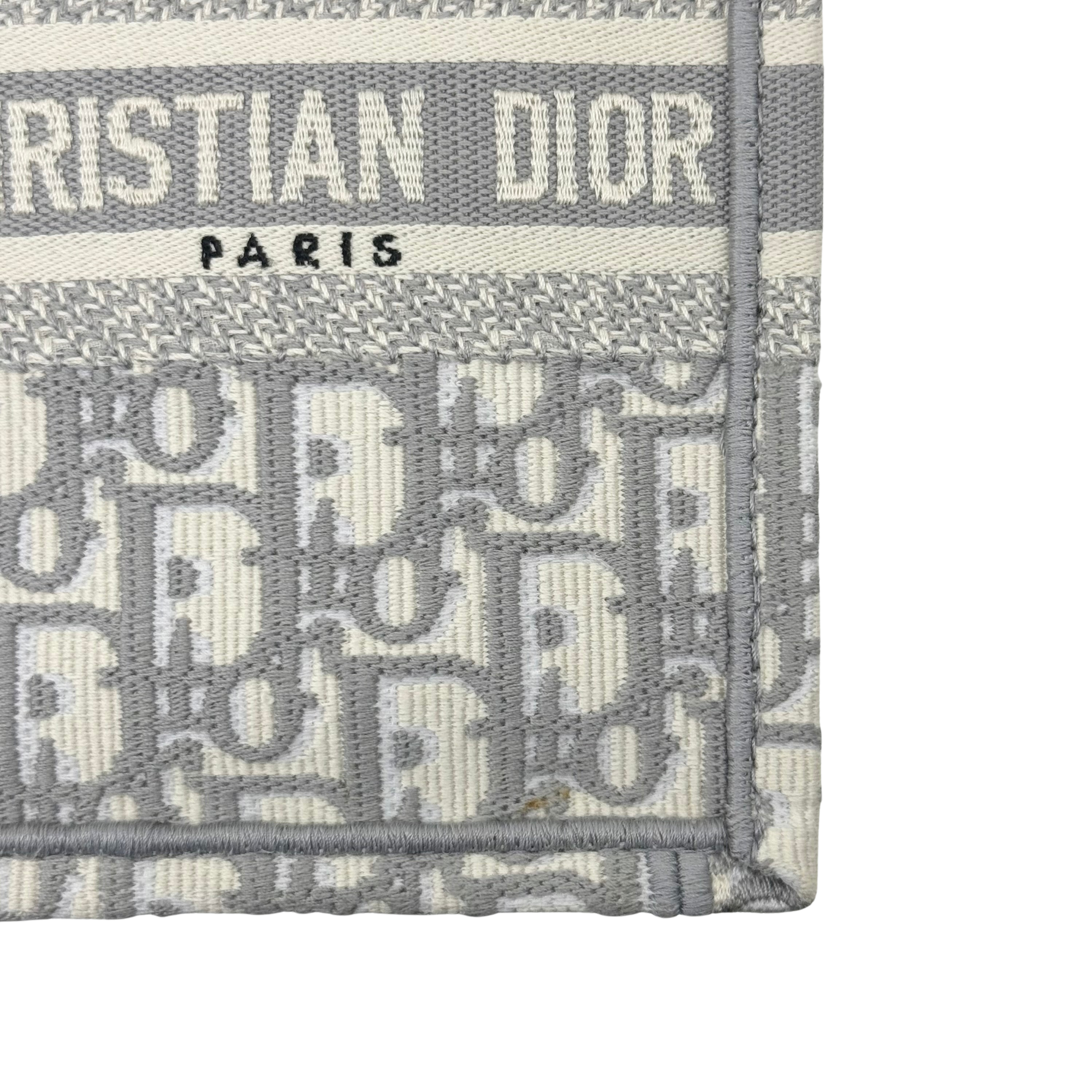 Gray Dior tote bag label patch reading CHRISTIAN DIOR PARIS