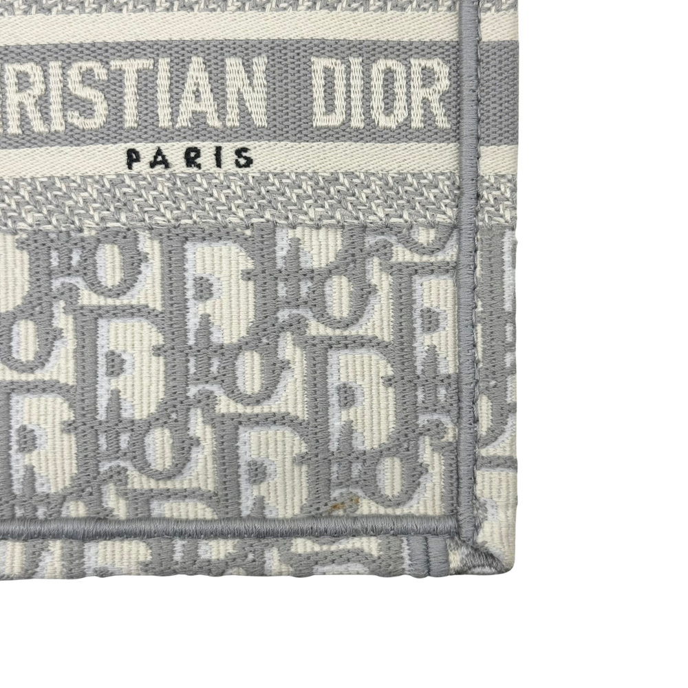 Gray Dior tote bag label patch reading CHRISTIAN DIOR PARIS