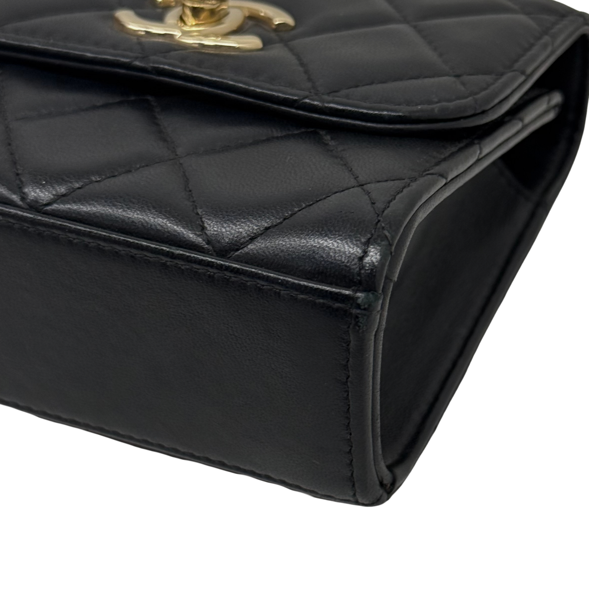 Black Chanel quilted mini flap bag corner with gold clasp and padded edge