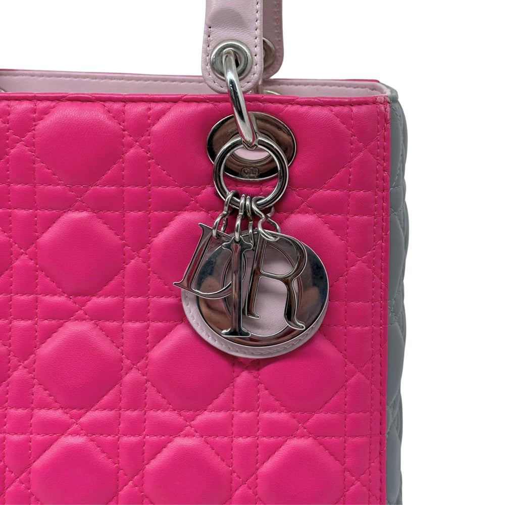 Fuchsia quilted handbag close-up with silver ring and logo-style charm