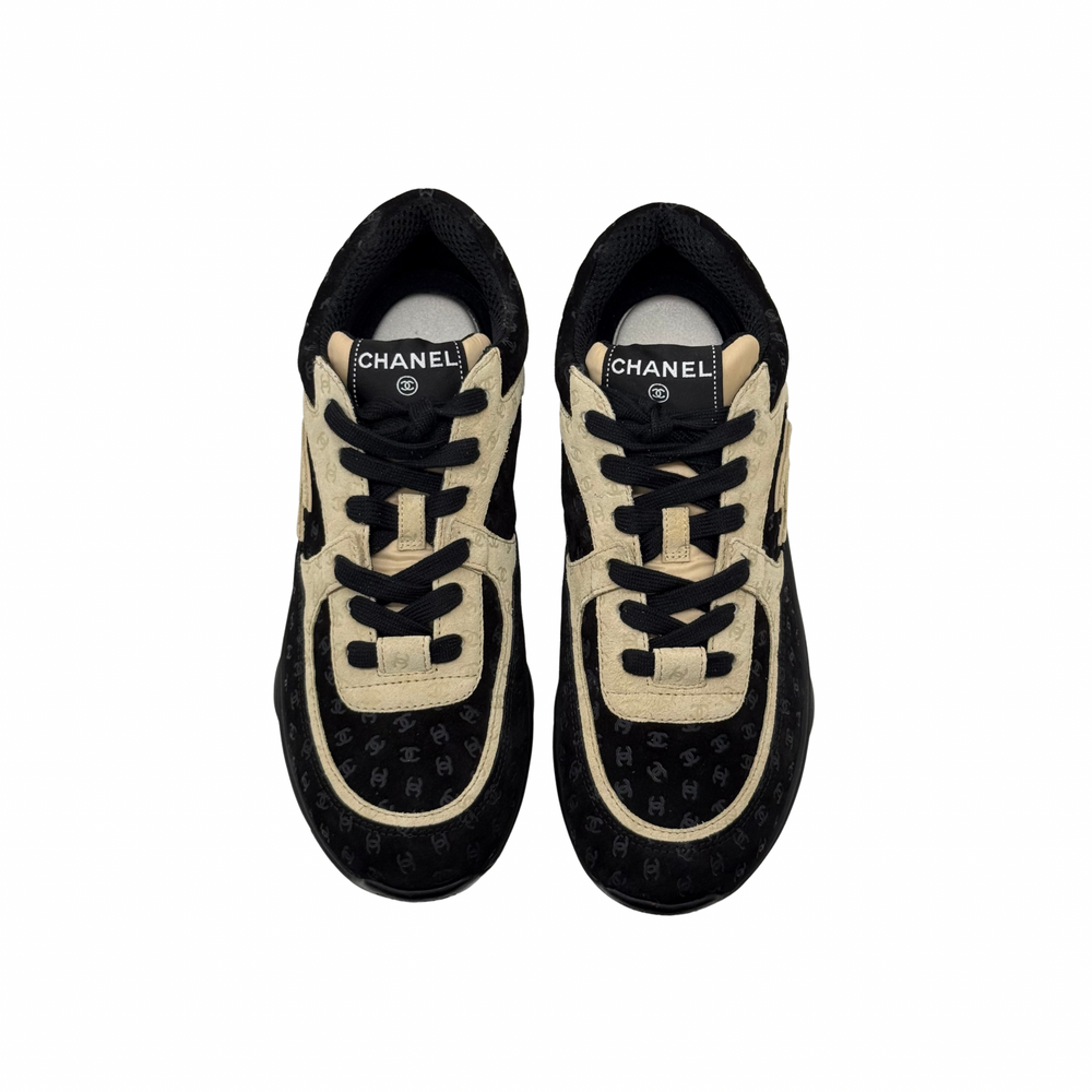 Black and beige Chanel sneakers front view with lace-up and logo detail on tongue