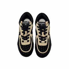 Black and beige Chanel sneakers front view with lace-up and logo detail on tongue