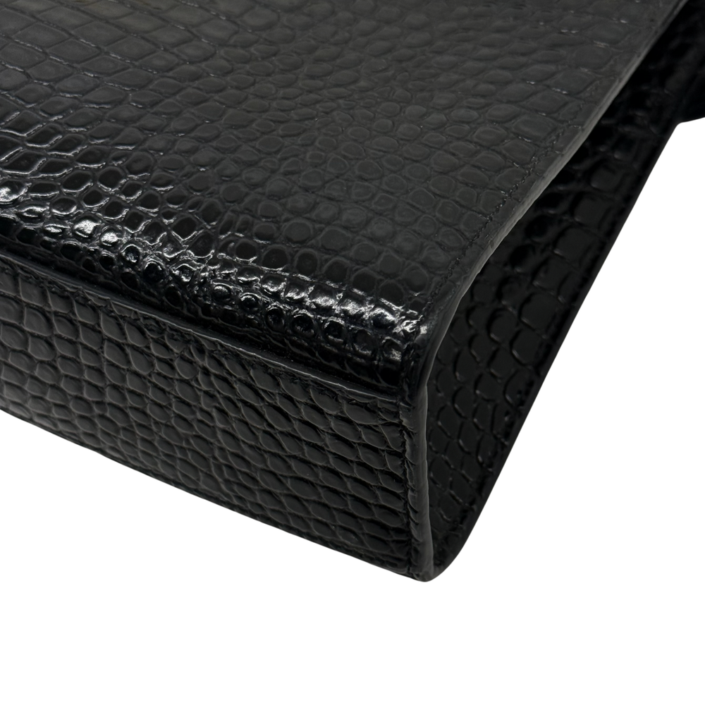 Black croc-embossed leather handbag corner and edge seam