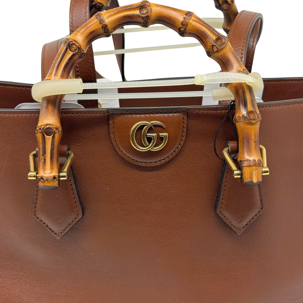Leather handbag front with GG emblem, brown bamboo handles, and gold clasps