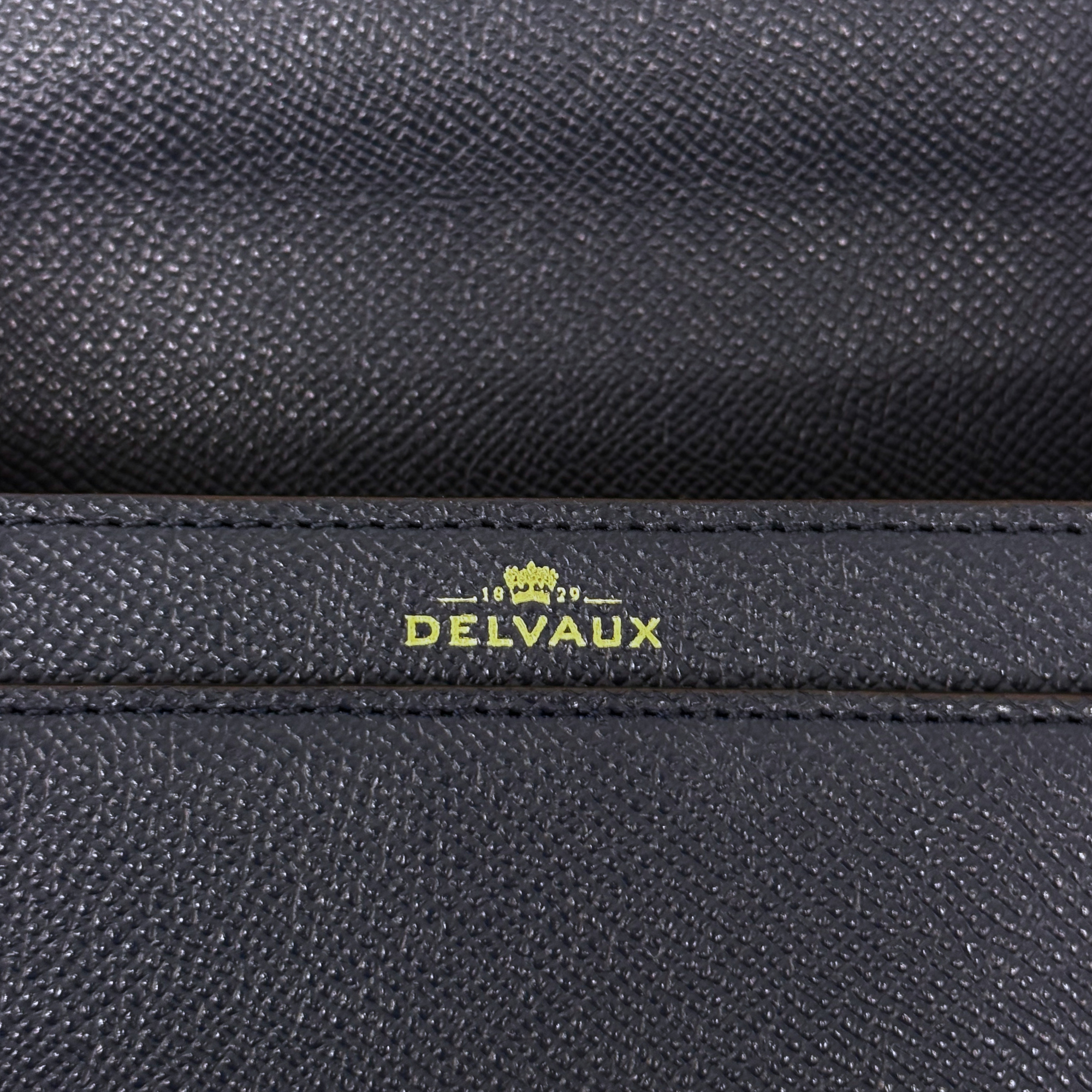 Pre-owned Delvaux bag close-up of textured leather with “DELVAUX” logo stamp