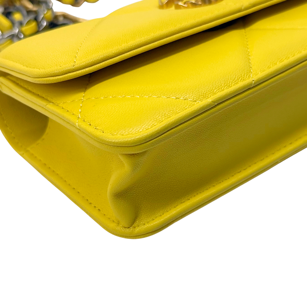 Yellow quilted leather mini bag corner with curved flap and stitching