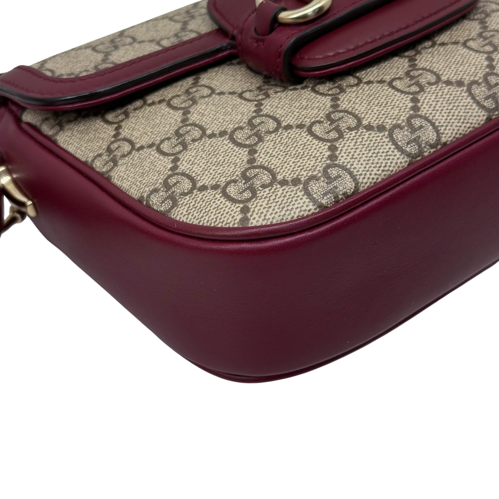 Gucci GG crossbody bag close-up with burgundy trim and canvas logo print