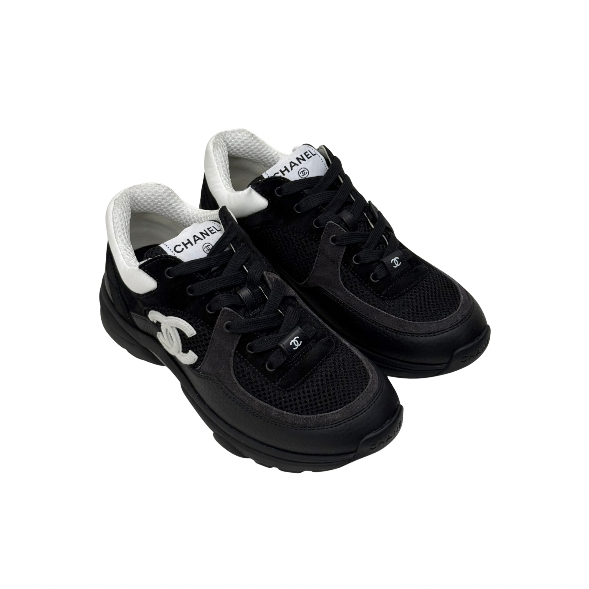 Black lace-up sneakers with white interior collar and Chanel logo on tongue.