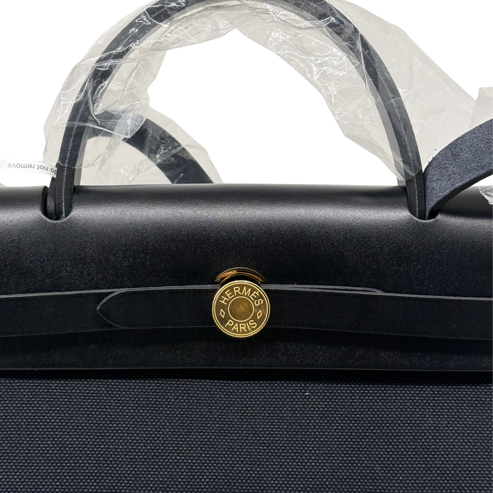 Hermes handbag close-up with Hermes Paris medallion and gold-tone top handles