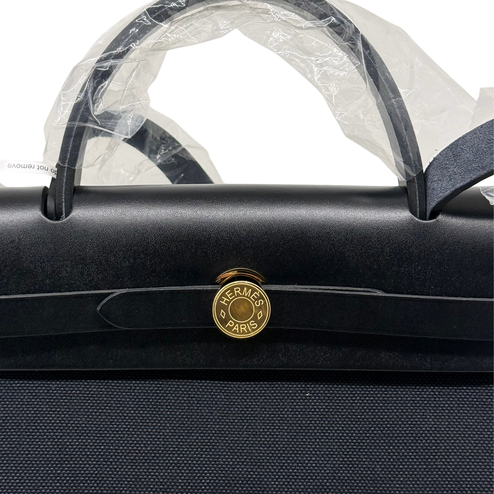 Hermes handbag close-up with Hermes Paris medallion and gold-tone top handles