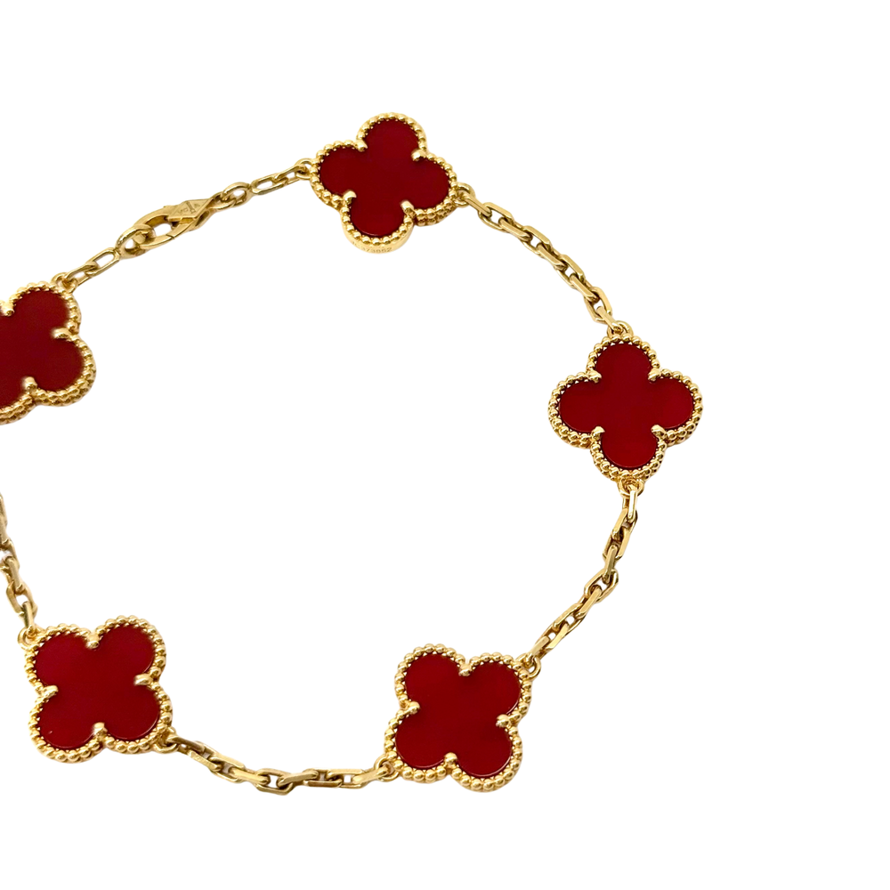 Goldtone bracelet with red enamel clover links, connected by curved chain