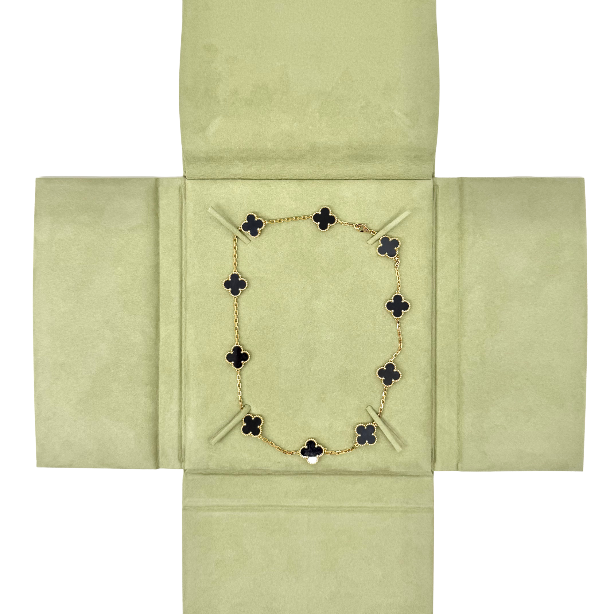 Van Cleef clover necklace laid in gift box with gold-tone chain and black motifs
