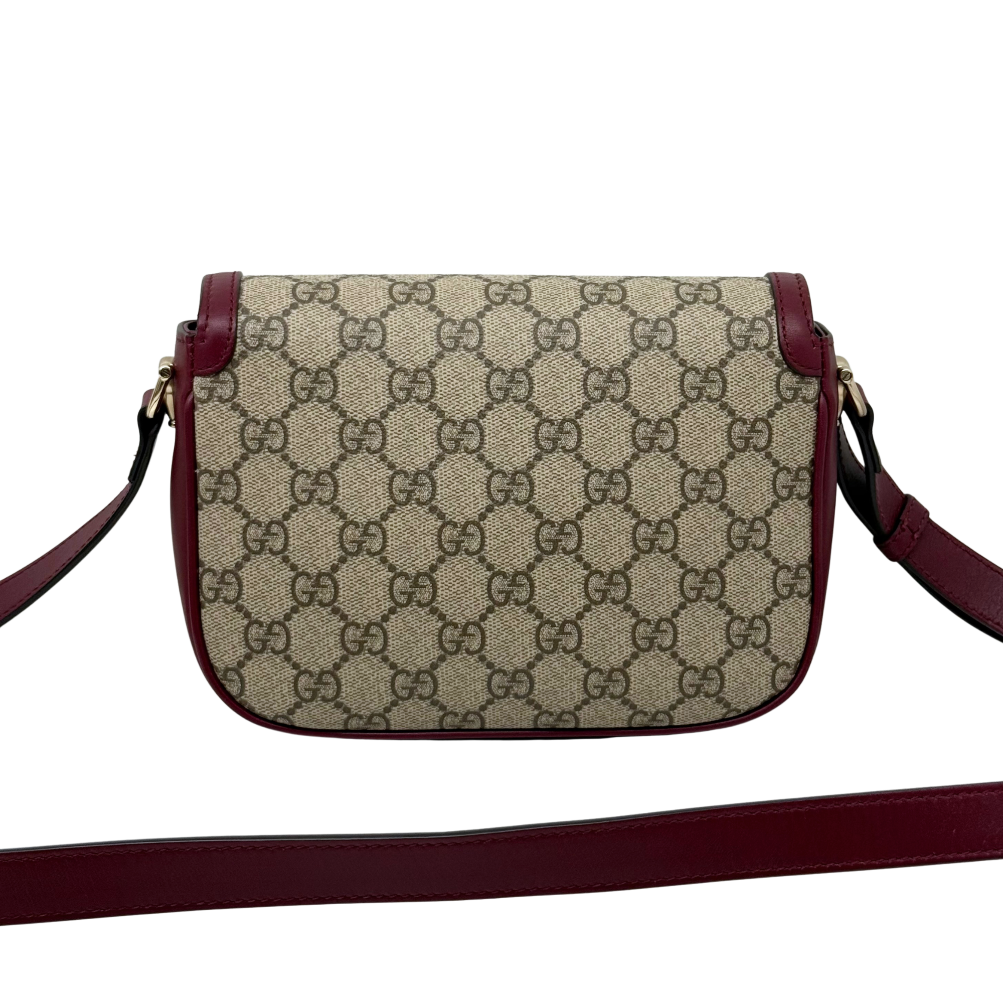 Gucci GG crossbody bag with burgundy strap, logo canvas, and gold buckle