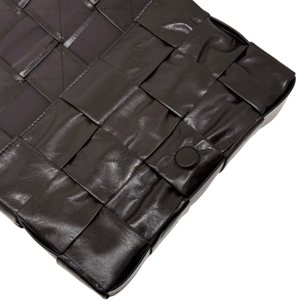 Quilted dark bag interior with molded panel segments and round snap button