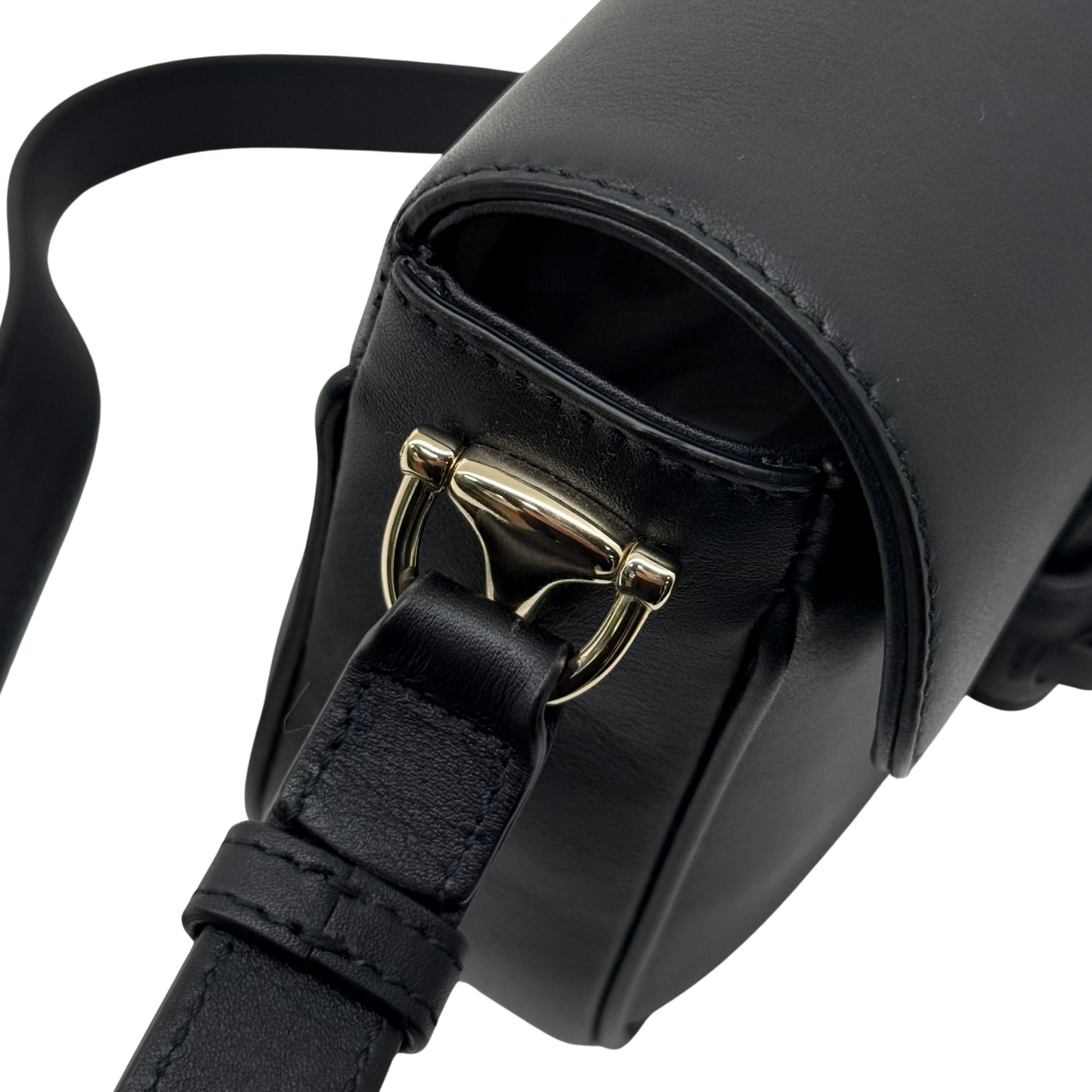 Gucci black leather bag close-up with gold buckles and adjustable strap detail