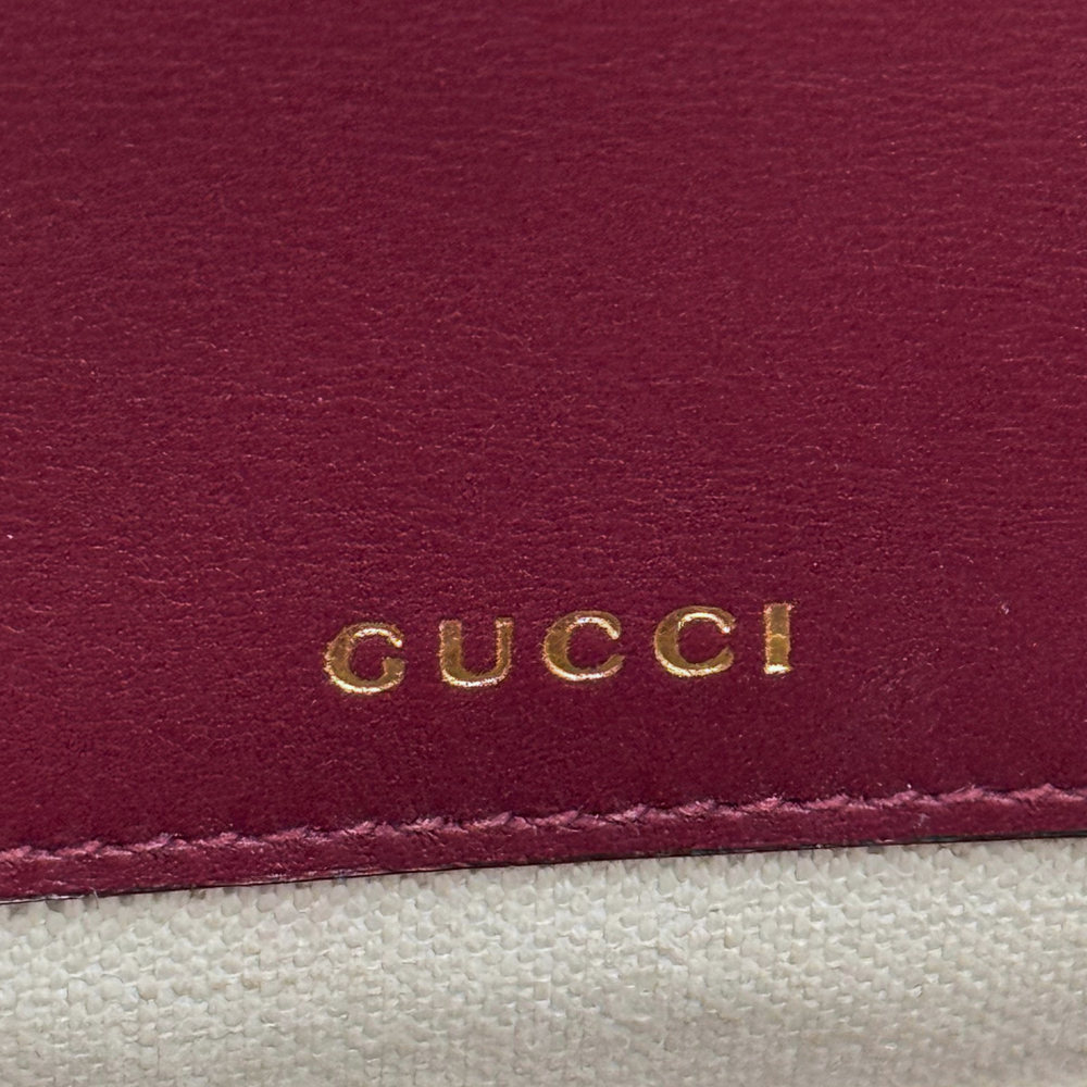 Burgundy leather panel with Gucci gold logo stamp