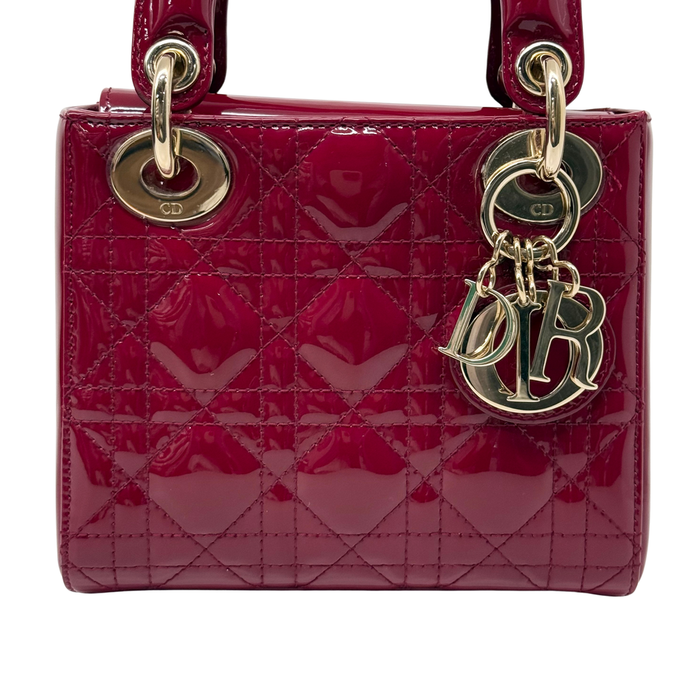 Red patent handbag with gold monogram charms and quilted front panel