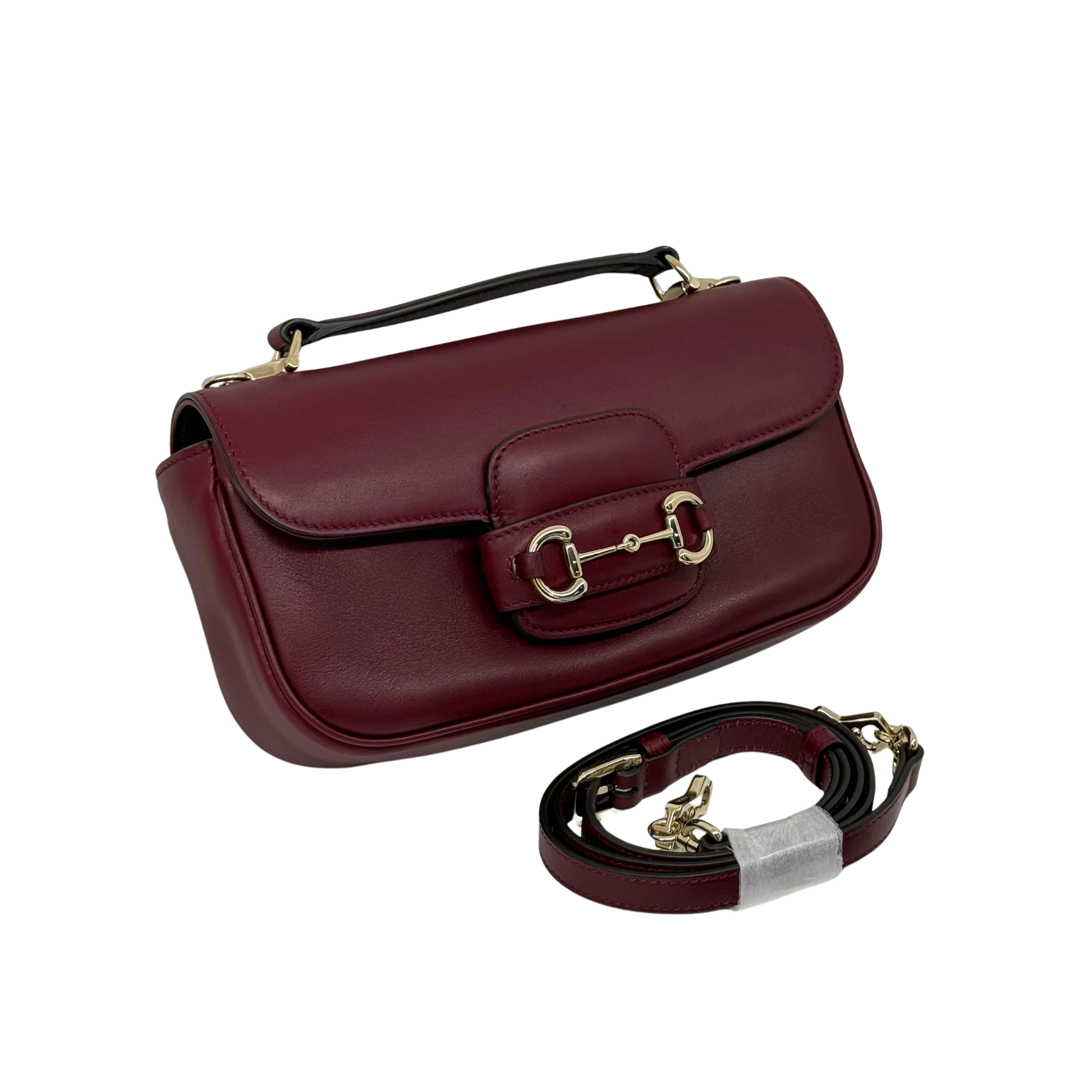 Maroon leather mini shoulder bag with front buckle clasp and adjustable strap