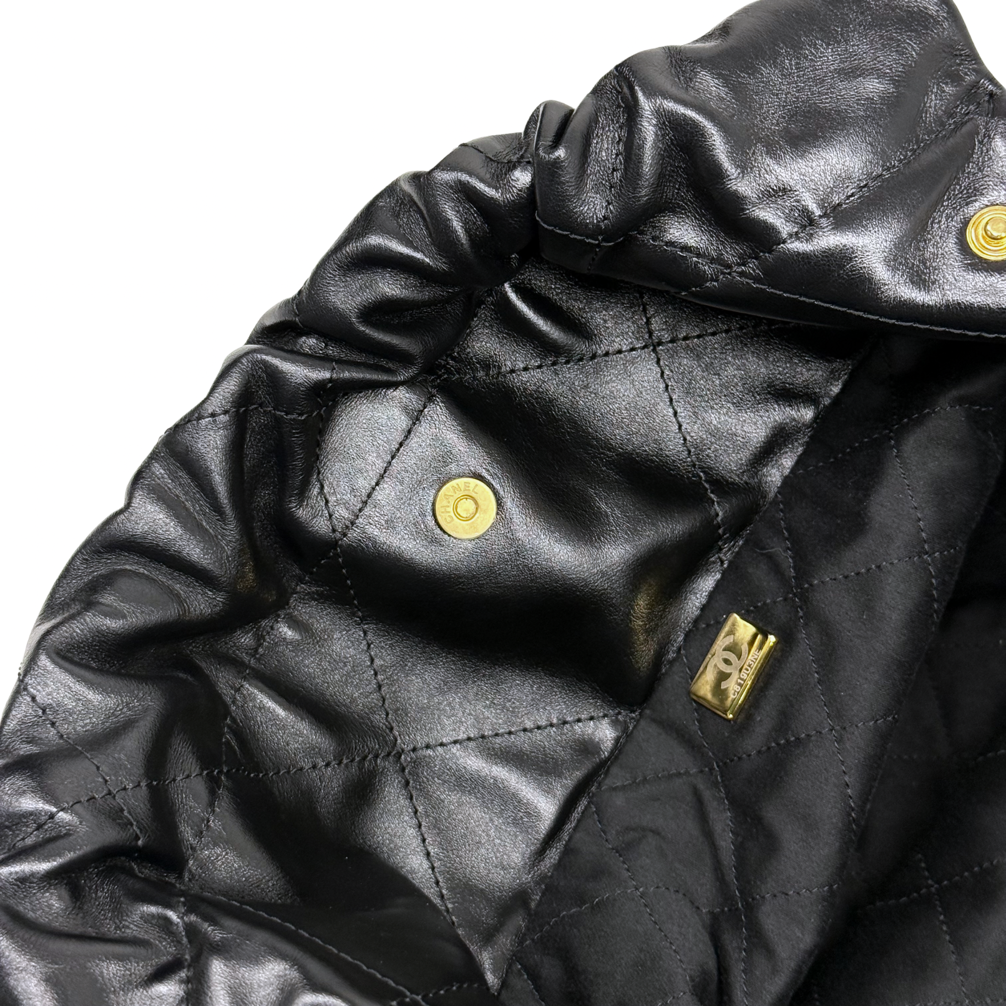 Black quilted leather interior flap with gold snap and stitched panels