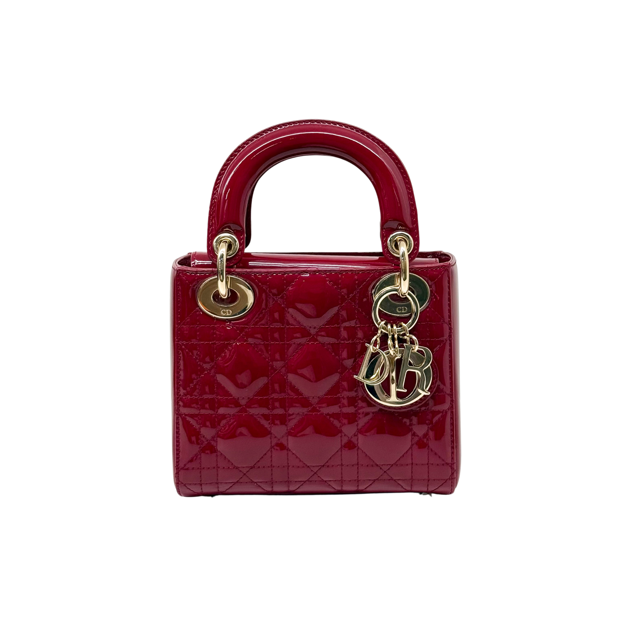 Red quilted patent handbag with gold top handles and dangling monogram charm