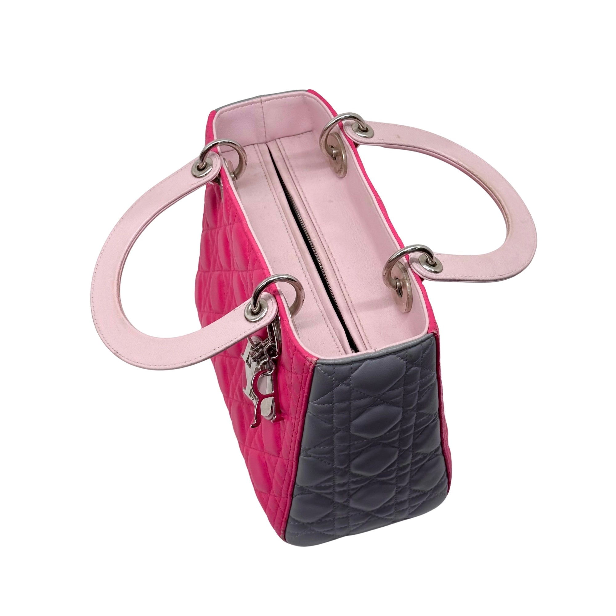 Two-tone quilted tote bag with top handles, open view showing zipper and interior