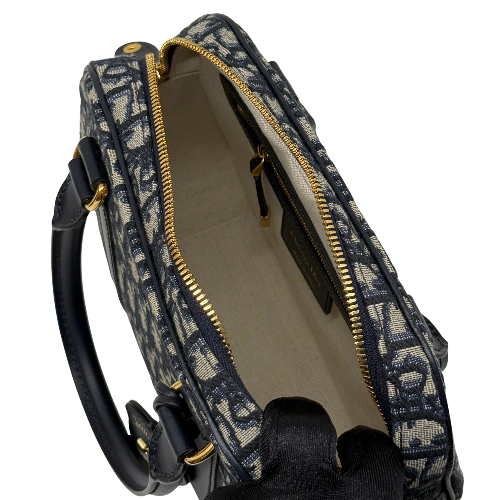 Navy and cream monogram handbag interior opening with beige lining and gold zipper