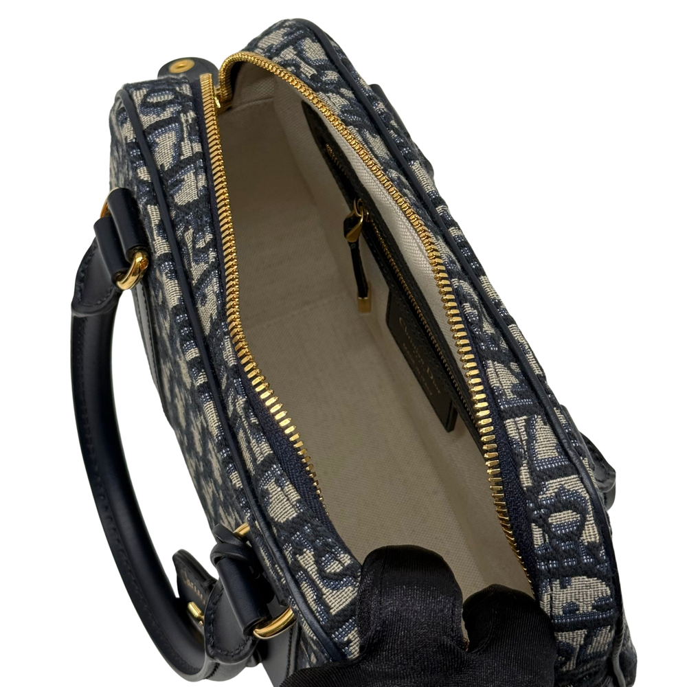 Navy and cream monogram handbag interior opening with beige lining and gold zipper